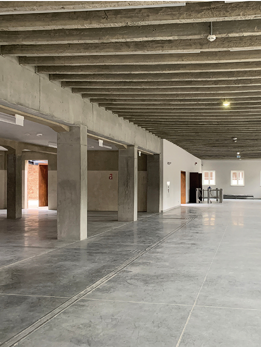 Wnętrze byłej rzeźni z zachowanymi belkami – świadkami historii; fot. Kozień Architekci